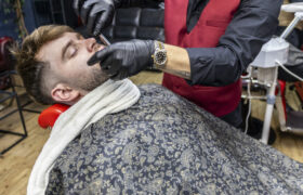 Barber performing shave on client