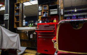 Interior of a barbershop with a red tool cabinet and barber chair