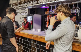 People socializing at a bar inside a barbershop